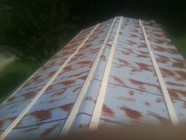 Rusted metal roof panels with new wood purlins before replacement — Storm Damage Roof Repair in Alledonia by Roofing Brothers