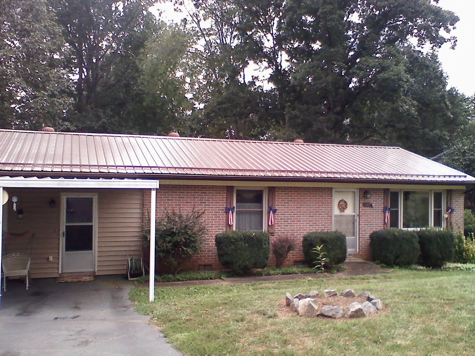 Bronze metal roof and carport on a brick ranch home — Roof Repair work by our crew in Alledonia